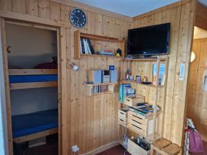 um quarto com beliches, uma televisão e um relógio em Appartement Les Arcs 1800, 2 pièces, 4 personnes - FR-1-346-549 em Arc 1800