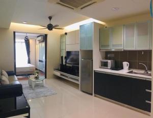 a kitchen with stainless steel appliances and a living room at Kuala Lumpur Bukit Bintang LaLaport Serviced Suite KLCC in Kuala Lumpur