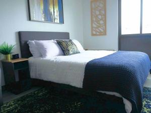 a bedroom with a bed with a blue and white blanket at Oslo Sapphire Flat in Murray