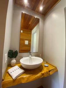 La salle de bains est pourvue d'un lavabo et d'un miroir. dans l'établissement Chalé do Lago Urupema SC, à Urupema