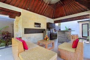 a living room with two couches and a kitchen at Agata Villas Seminyak in Seminyak