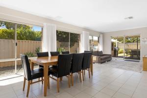 a dining room with a wooden table and black chairs at Sandylands Busselton with WiFi in Vasse