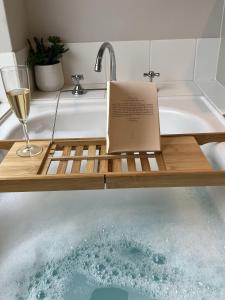 a book sitting on a wooden cutting board in a bath tub at Sandylands Busselton with WiFi in Vasse