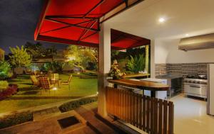 an open kitchen and dining room with a view of a garden at Agata Villas Seminyak in Seminyak