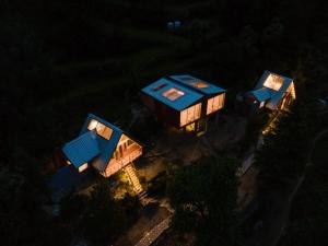 una vista aérea de una casa en el árbol por la noche en Stargazing Cottages Jibhi en Jibhi
