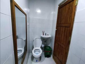 baño con 2 aseos, lavamanos y puerta en LA CHOZA, en Mompox