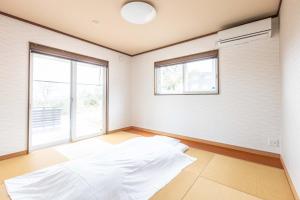 a room with a large white bed in it at ふくろう庵-白浜- in Shirahama