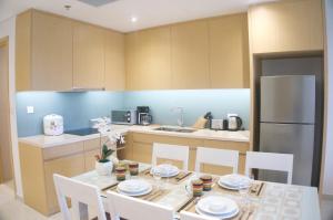 a kitchen with a table with chairs and a refrigerator at Ocean Apartment in Da Nang