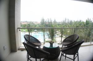 a balcony with a table and chairs and a view of a pool at Ocean Apartment in Da Nang