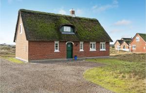 uma casa com um telhado de relva com uma porta verde em Lovely Home In Fan With Sauna em Sønderho