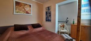 a bedroom with a bed and a dresser and a chair at Apartament przy Rynku in Białystok