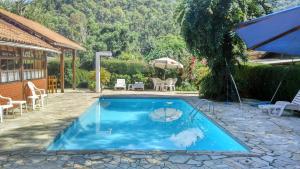 una piscina en un patio con una casa en Pousada Montserrat, en Visconde De Maua