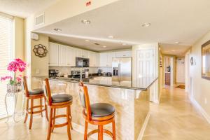 a kitchen with a bar with chairs and a counter top at Majestic Beach Resort Tower 2- 801 in Panama City Beach