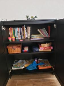 una estantería de libros negros con libros y libros en Popsie's Paradise, en Jarbang