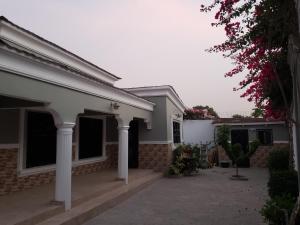 a white house with columns and a courtyard at Popsie's Paradise in Jarbang