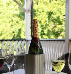 Alpine Hotel Bright في برايت: زجاجة من النبيذ موضوعة على طاولة مع كؤوس للنبيذ