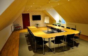 une grande salle de conférence avec une grande table et des chaises dans l'établissement Nils Holgerssongården, à Skurup