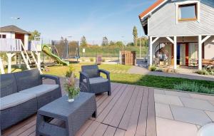 patio con sofá, sillas y parque infantil en Lovely Home In Karwia, en Karwia