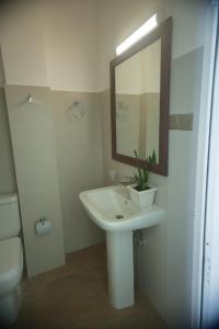 een badkamer met een wastafel, een spiegel en een toilet bij Tranquil Edge Villa in Haputale
