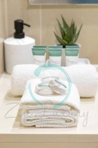 - une pile de serviettes sur un comptoir dans la salle de bains dans l'établissement Zen Ocean Charm 3BR Luxury W/front Apt Pool + BBQ, à Darwin