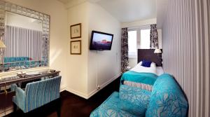 a hotel room with a bed and a television at Home Hotel Bastion in Oslo