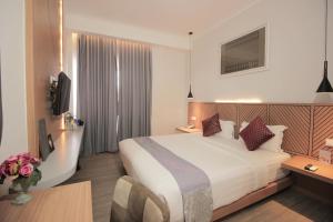 Tempat tidur dalam kamar di Muara Hotel Bukittinggi