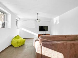 a living room with a couch and a tv at Chalet Familial Les Girolles aux portes d'Anzère in Arbaz