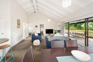 un soggiorno con letto, tavolo e sedie di Waitahanui Lake House - Lake Taupo Holiday Home a Waitahanui