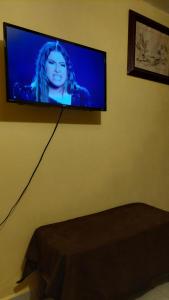 TV de pantalla plana colgada en la pared en RELAJACION SERCAS DEL AEROPUERTO, 