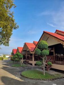 una fila de edificios con techos rojos en สุขทวีรีสอร์ท อ่าวมะนาว, en Prachuap Khiri Khan