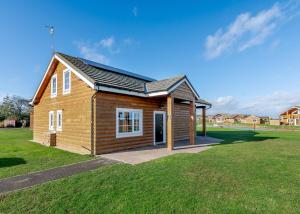 a small wooden house in a grassy field at Hornsea Lakeside Lodges in Hornsea