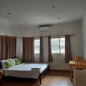 a bedroom with a bed and two windows at Happy Hostel in Bangkok