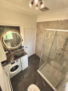 een badkamer met een douche, een wastafel en een spiegel bij Berghofen in Mount Tamborine