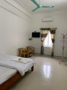 - une chambre avec un lit et un ventilateur de plafond dans l'établissement Nhà nghỉ Chiều Tím, à Lạng Sơn