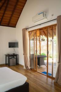 1 dormitorio con 1 cama y puerta corredera de cristal en The Blue Lagoon Resort Kalpitiya en Kalpitiya