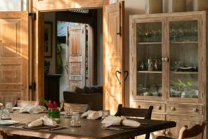 a dining room with a table and a china cabinet at Taru Villas Rampart Street - Galle Fort in Galle