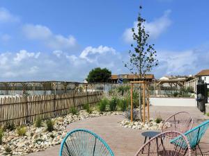 a patio with chairs and a tree in a yard at Studio Cabine à Le Barcarès, 4 couchages, terrasse, parking, piscine et activités sportives - FR-1-195-23 in Le Barcarès +9 photos