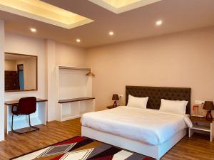 a bedroom with a bed and a desk and a chair at THE APARTMENT in Gangtok