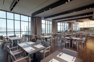 a restaurant with tables and chairs and large windows at Shilla Stay Yeosu in Yeosu