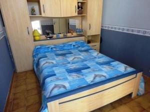 - un lit avec une couette bleue dans l'établissement Maison Port-la-Nouvelle, 3 pièces, 6 personnes - FR-1-229C-382, à Port-la-Nouvelle