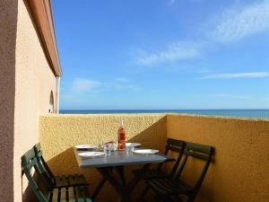 a table and chairs on a balcony with the ocean at Appartement Fleury-Saint-Pierre-la-Mer, 2 pièces, 4 personnes - FR-1-229D-280 in Saint Pierre La Mer