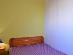 a small bedroom with a bed with purple sheets at Appartement Fleury-Saint-Pierre-la-Mer, 2 pièces, 4 personnes - FR-1-229D-280 in Saint Pierre La Mer