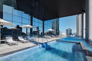 a swimming pool with chairs and umbrellas on a building at Shilla Stay Yeosu in Yeosu
