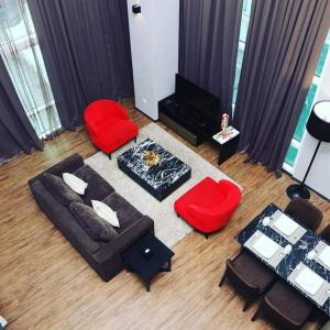 a living room with a couch and red chairs at Urbano Luxury Maritime Suite in George Town