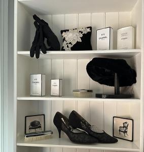 ein Schrank mit schwarzen Schuhen und anderen Gegenständen auf Regalen in der Unterkunft Penghana Bed and Breakfast in Queenstown