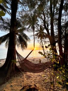 a hammock on a beach with a sunset in the background at BEACH BUNGALOW - OUTDOOR net on the beach - Working Desk in Lipa Noi