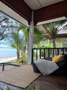 a bed on a porch with a view of the beach at BEACH BUNGALOW - OUTDOOR net on the beach - Working Desk in Lipa Noi