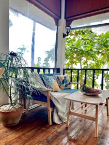 a couch on a porch with plants and a table at BEACH BUNGALOW - OUTDOOR net on the beach - Working Desk in Lipa Noi