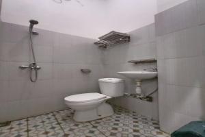 a bathroom with a toilet and a sink at OYO 92207 Hotel Koperasi in Banda Aceh