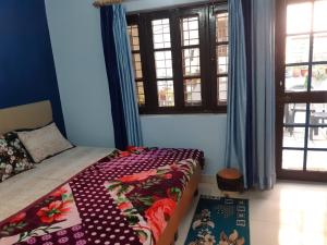 a bedroom with a bed and two windows and a bed sidx sidx sidx at Gungun Homestay in Rishīkesh